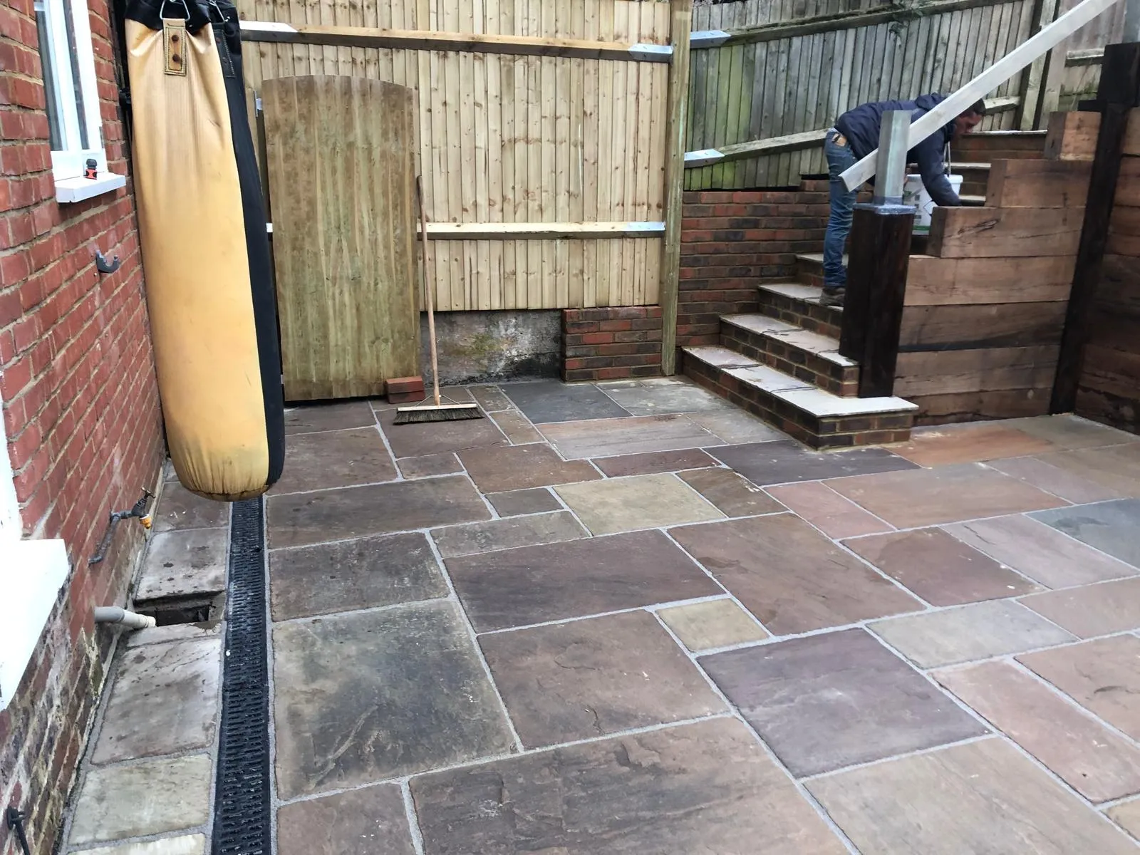 From the house end: the steps with their handrail, and a drainage channel along the patio.