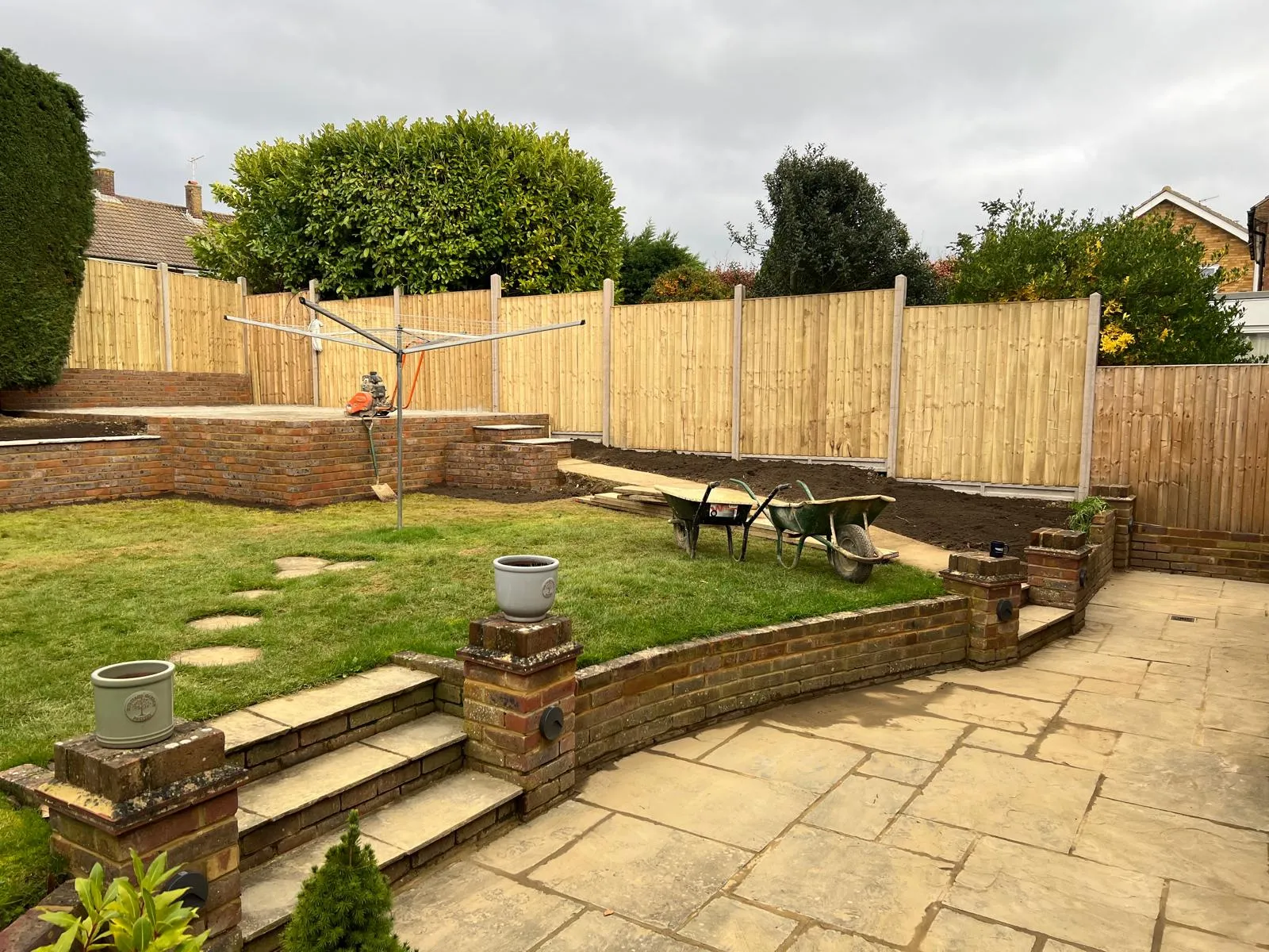 Terraced garden: Brick terracing and steps, with an Indian sandstone patio at the lower level.