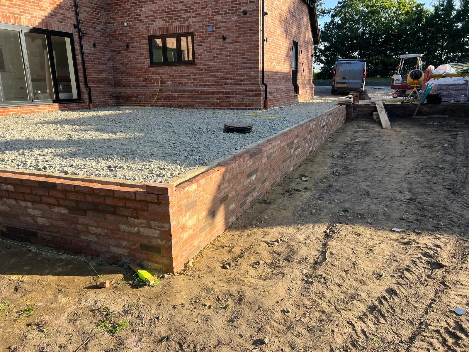 New-build retaining walls: A finished wall holding a gravel terrace.