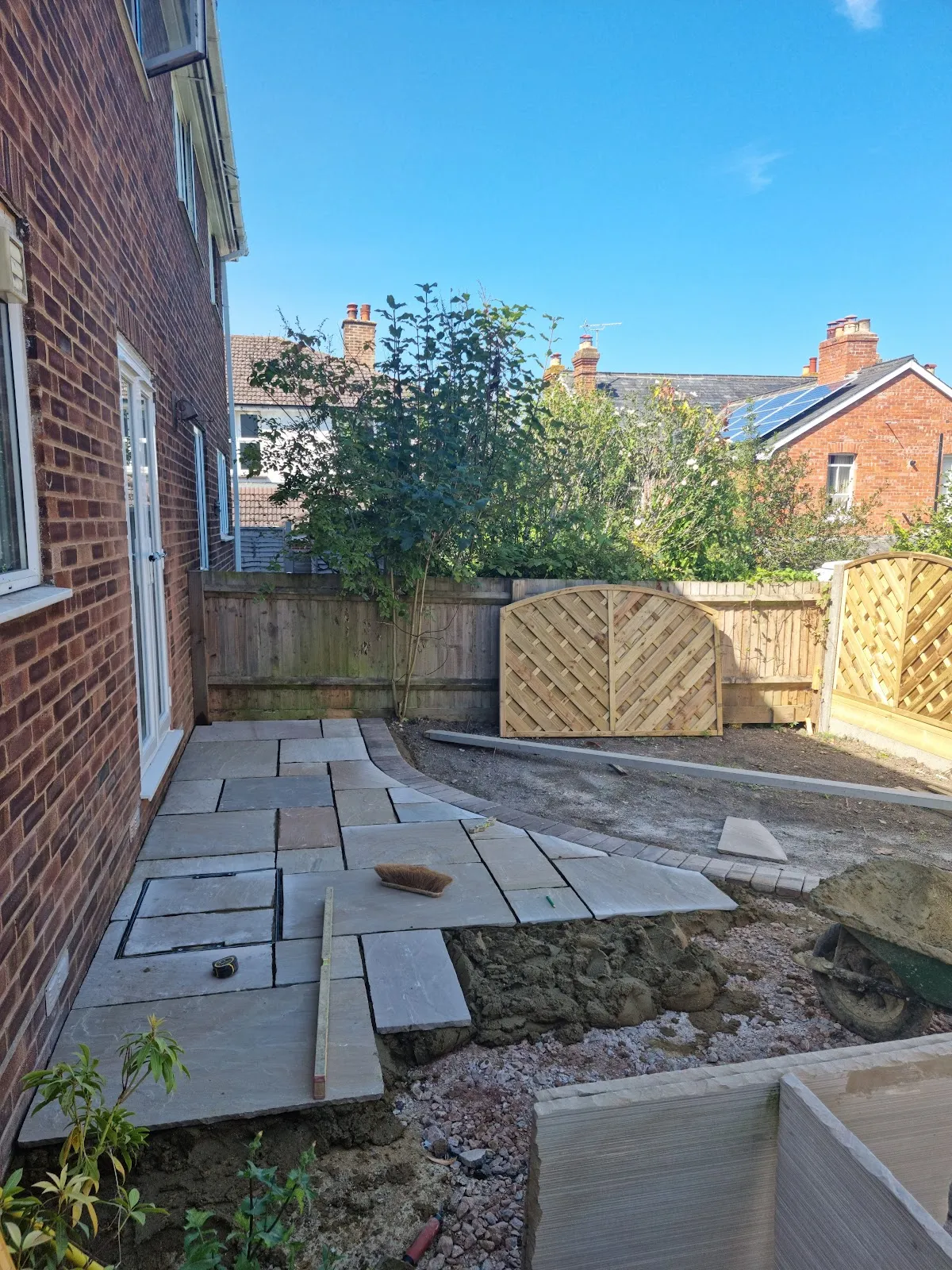 Sandstone slabs being laid along the house wall