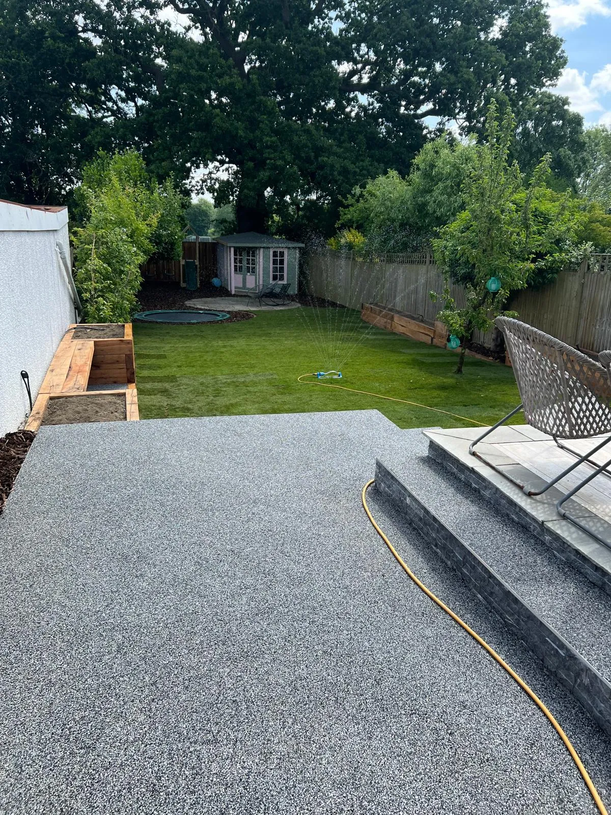 The resin terrace finished, with new turf beyond it.